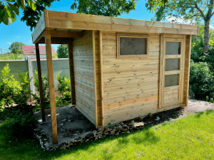 Abri de jardin moderne en bois avec auvent, sur pelouse.