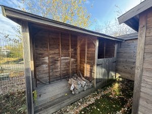 Abri en bois rustique avec du bois de chauffage en automne.
